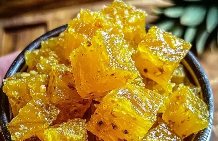 Homemade Pineapple Cowboy Candy in a glass jar with spices and ingredients